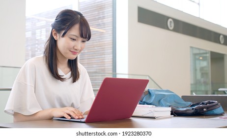 Young Asian Female Student Using A Laptop Pc.