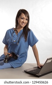 Young Asian Filipino Nurse Working On Laptop