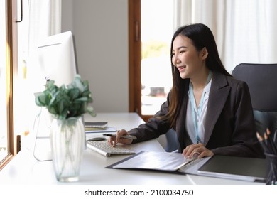 Young Asian Finance Market Analyst Working At The Office On Desktop Computer. Business Woman Analyse Document On Her Desk.