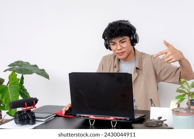 A young Asian freelance video editor with headphones dissing someone during a video conference debate. - Powered by Shutterstock