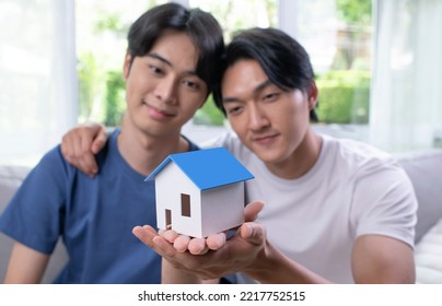 Young Asian Gay Couple Is Holding A Model House In Hand, LGBT Male Couple Saving Money For Family And Home, New Home.