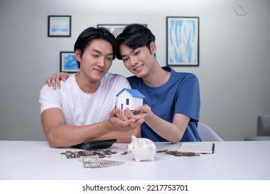 Young Asian Gay Couple Saving Money To Buy A House. LGBT Male Couple Saving Money For Family And Home.