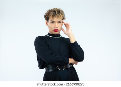 Young Asian Gay Man In Black Blouse Dress Wearing Necklace Posing Thinking On The White Screen Background.