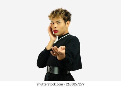 Young Asian Gay Man In Black Dress Wearing Necklace Posing Hand Presenting Pointing On The White Screen Background.