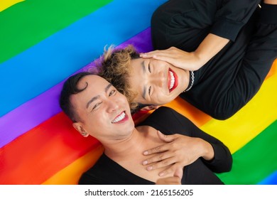 Young Asian Gay Man Couple In Black Shirt Lay On The Pride Flag In The Concept Of Lgbt Or Lgbtq And Lgbtq+.