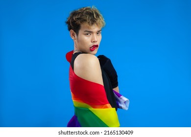 Young Asian Gay Man With Pride Flag Posing On The Blue Screen Background. 