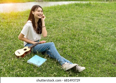 Young Asian Girl Artist With Ukulele Classic, Book And Listening Music Singer Pop Solo Sound Smiling Lifestyle In Park Nature Summer Of Vacation Time.