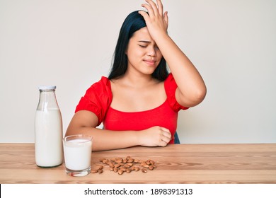 Young Asian Girl Drinking Healthy Almond Milk Surprised With Hand On Head For Mistake, Remember Error. Forgot, Bad Memory Concept. 