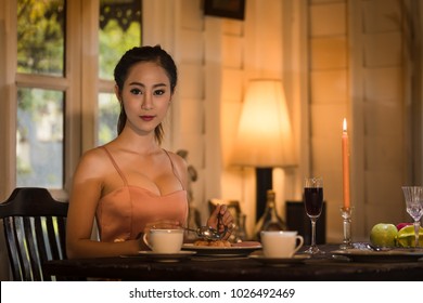 Young Asian Girl In Evening Dress Dinner Under Candlelight Alone