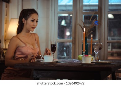 Young Asian Girl In Evening Dress Dinner Under Candlelight Alone