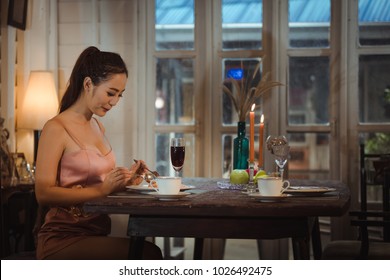 Young Asian Girl In Evening Dress Dinner Under Candlelight Alone