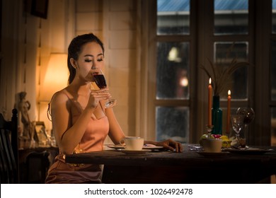 Young Asian Girl In Evening Dress Dinner Under Candlelight Alone