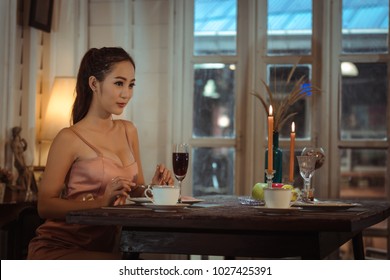 Young Asian Girl In Evening Dress Dinner Under Candlelight Alone