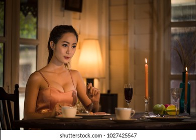 Young Asian Girl In Evening Dress Dinner Under Candlelight Alone