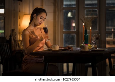 Young Asian Girl In Evening Dress Dinner Under Candlelight Alone