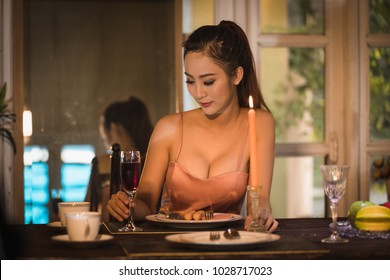 Young Asian Girl In Evening Dress Dinner Under Candlelight Alone