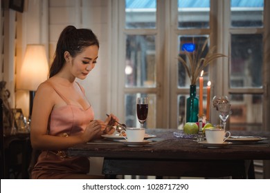 Young Asian Girl In Evening Dress Dinner Under Candlelight Alone