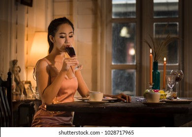 Young Asian Girl In Evening Dress Dinner Under Candlelight Alone