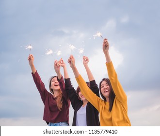 young asian girl friends play firework sparklers and have fun at new year party.group of female people happy lifestyle enjoy hangout at outdoor evening sunset on roof top.city holiday celebration