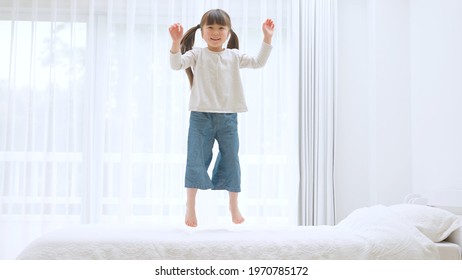 Young Asian Girl Jumping On The Bed