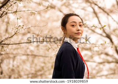 young asian girl look down to see plum blossoms in winter.