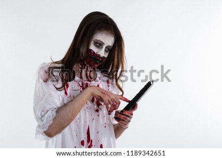 young asian girl make up artist design face ghost and zombies in halloween concept and holding hands with remote television control on white background isolate