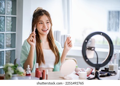 Young Asian girl makeup artist Professional Woman blogger vlogger is showing cosmetics products with recording video Beauty influencer asian girl video online marketing - Powered by Shutterstock