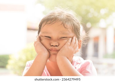 Young Asian girl in pink shirt feeling bored on chair. Depressed girl sits on chair with sad mood. - Shutterstock ID 2364279495