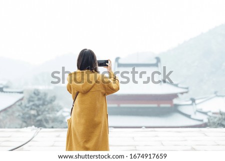 A young Asian girl is playing in the snow