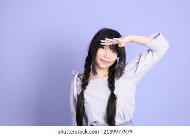 The Young Asian Girl In Purple Preppy Dressed Standing On The Purple Background.