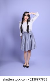 The Young Asian Girl In Purple Preppy Dressed Standing On The Purple Background.