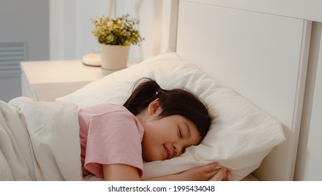 Young Asian Girl Sleeping At Home. Asia Japanese Woman Child Kid Relax Rest Asleep Lying On Bed, Feel Comfort And Calm In Bedroom At Home At Night Concept.