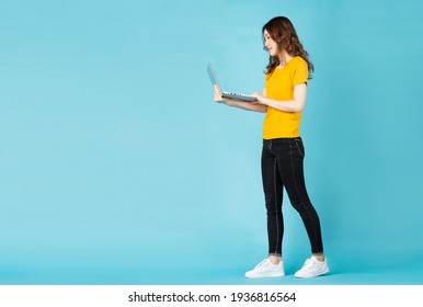 Young Asian Girl Standing Using Laptop On Background