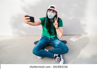 Young Asian Girl Taking A Selfie With Smartphone While Wearing Protective Face Mask - Coronavirus Lifestyle