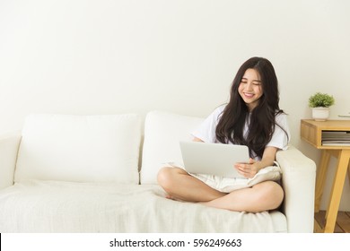 Young Asian Girl Using Laptop On The Couch