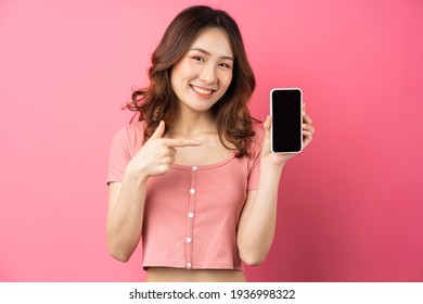 Young Asian Girl Using The Phone On Pink Background