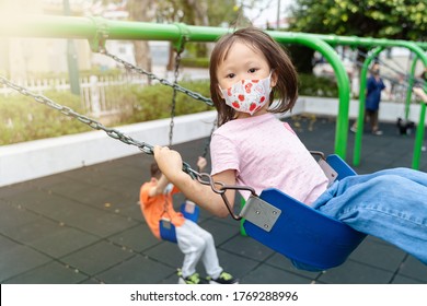 Young Asian Girl Wearing Mask Playing Outdoor Playground Swinging Having Fun