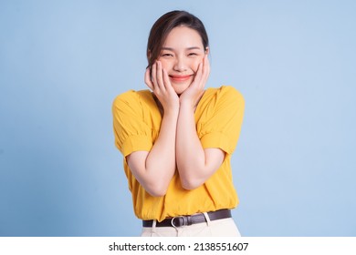 Young Asian Girl Wearing Yellow Shirt Posing On Blue Background