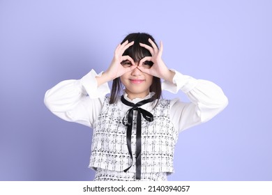 The Young Asian Girl In White Preppy Dressed Standing On The Purple Background.