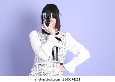 The Young Asian Girl In White Preppy Dressed Standing On The Purple Background.