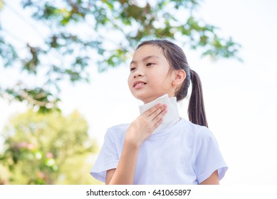 Young Asian Girl Wipe Her Sweat By Tissue Paper In Park