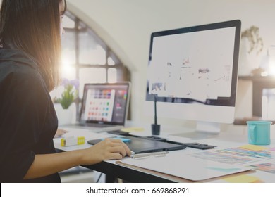 Young Asian Graphic Designer Working On Computer Using Digital Tablet At Office.