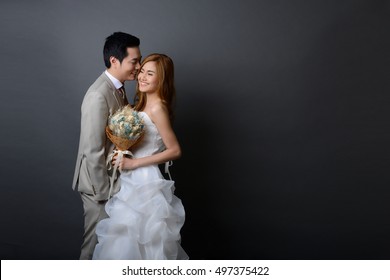 young asian groom and bride posing and smiling in studio for pre-wedding shot.