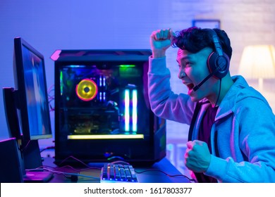 Young Asian Handsome Pro Gamer Feel Excited While playing in Online Cyber Sport Game at home
