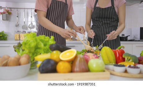 Young Asian Happy Couple Is Preparing Healthy Meal In Their Kitchen. Happy Active Young Couple Having Enjoying Together. Healthy Nutrition Salad Concept For Foodie Love. Healthy Food.