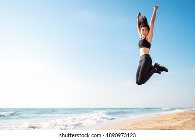 Young Asian Healthy Athletic Slim Woman Smiling Jumping On Beach