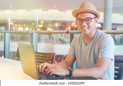 Young Asian Hipster Man Using Laptop And Smile