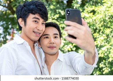 Young Asian Homosexual Couple Taking Self Portrait With Smart Phone.Concept LGBT Gay.