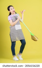 Young Asian Housewife Posing On Yellow Background