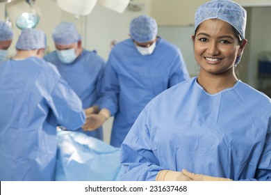 Young Asian Indian Female Woman Nurse Doctor Surgeon With Her Interracial Surgical Team Working On A Patient In Hospital Surgery Operating Theater